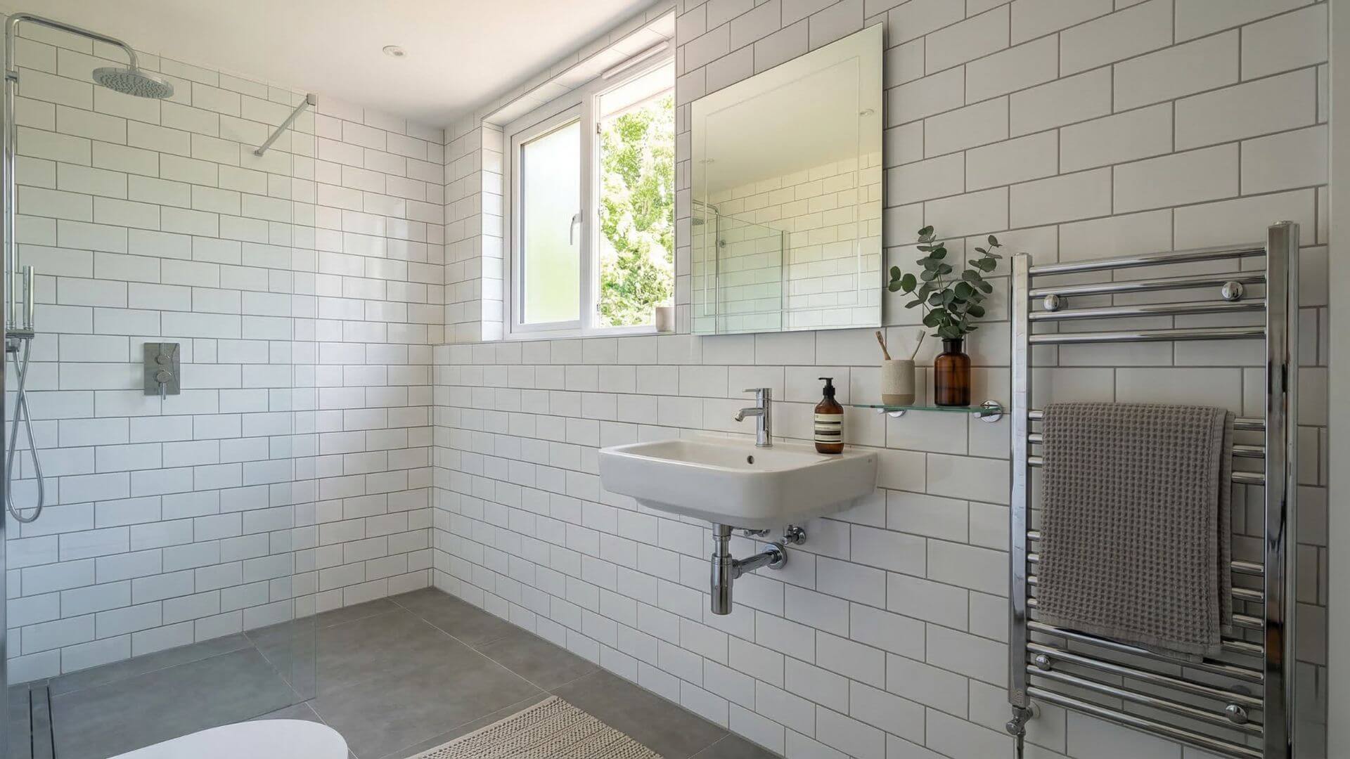 Coordinated grey porcelain floor tiles and white ceramic wall tiles in a modern UK bathroom